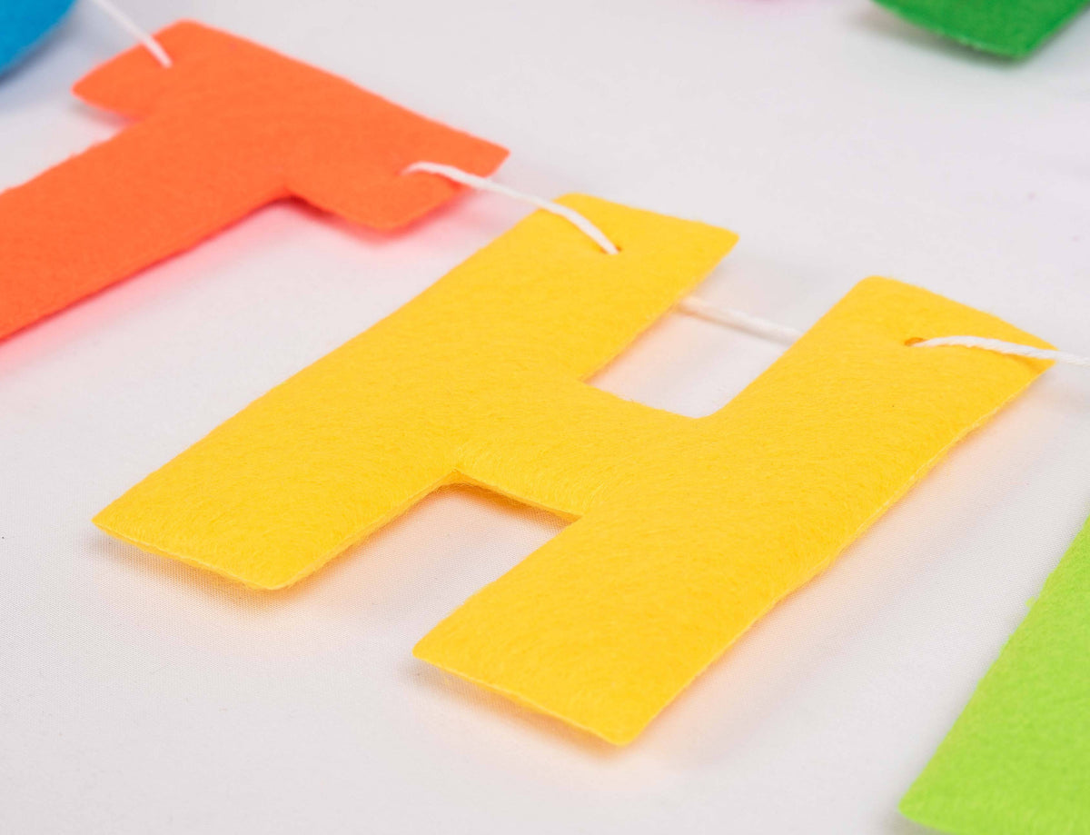 Felt letter banner spelling "Happy Birthday" by Party Partners, colorful garland for birthday celebration decorations.