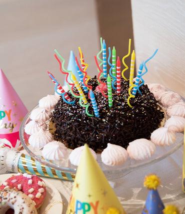 Rainbow striped candle set featuring 16 colorful candles from Party Partners, perfect for celebrations and decorative displays.