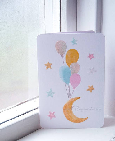 Pictura Moon Stars & Balloons Baby Card featuring colorful moon, stars, and balloons on a cheerful background.