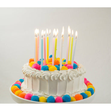 Set of tall pastel rainbow candles by Pictura, featuring vibrant multicolored wax in a decorative candle arrangement.